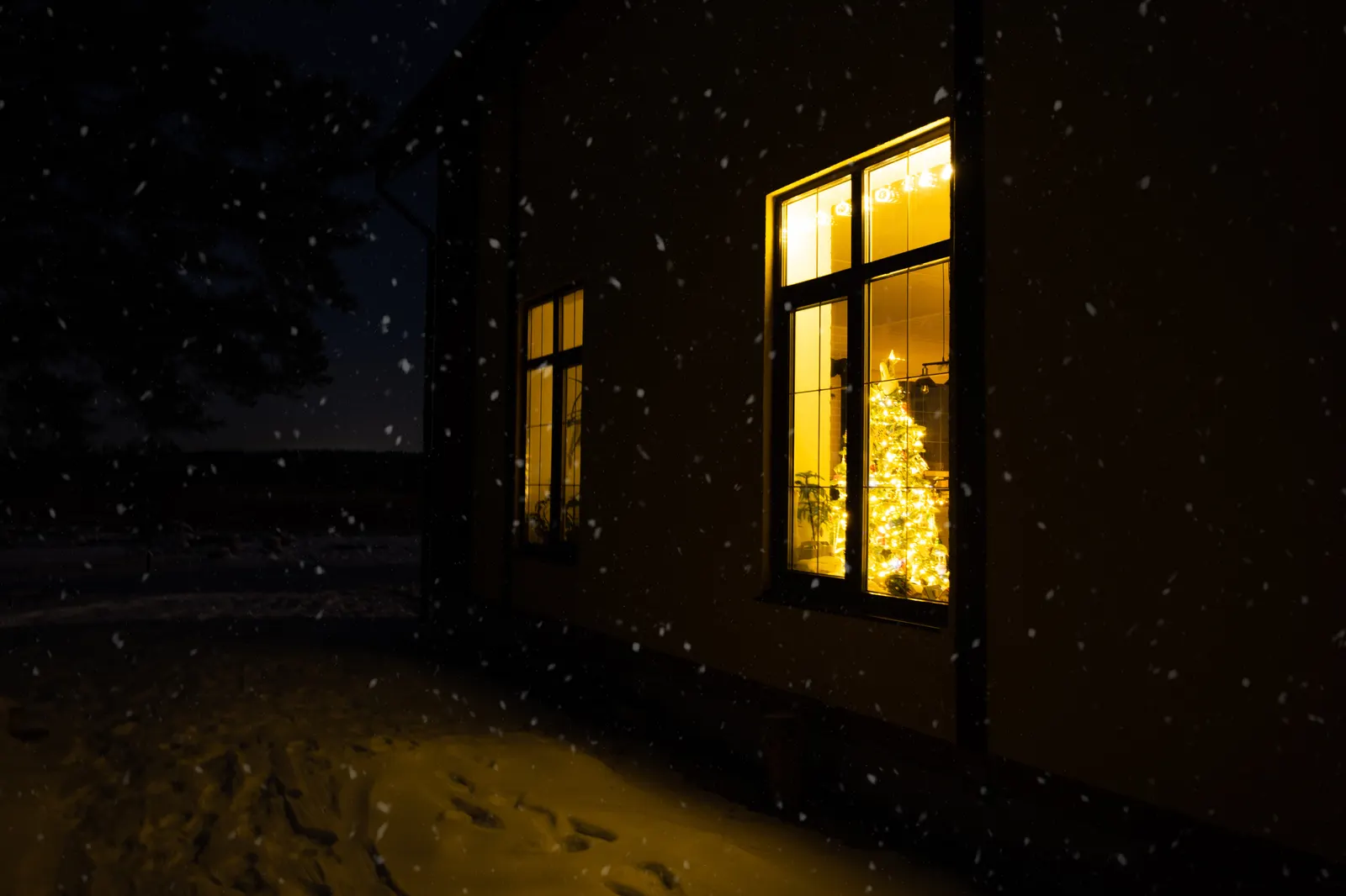 Two-storey Iowa City house with warm lit windows on a winter evening